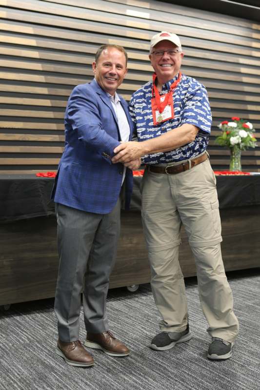 two men shaking hands in front of a table