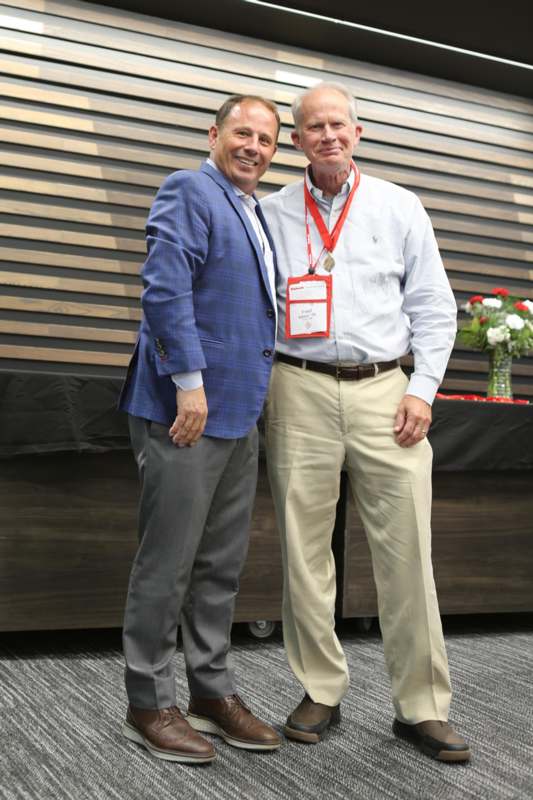 two men standing together smiling