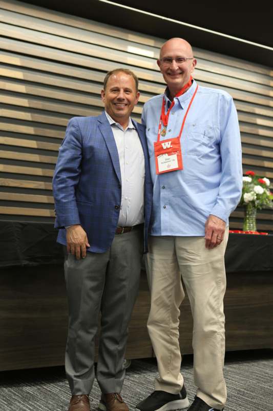 two men standing together smiling