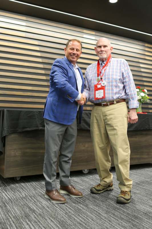 two men shaking hands in front of a table