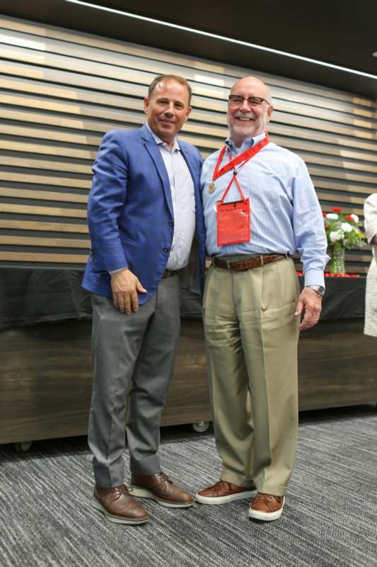 two men standing together smiling