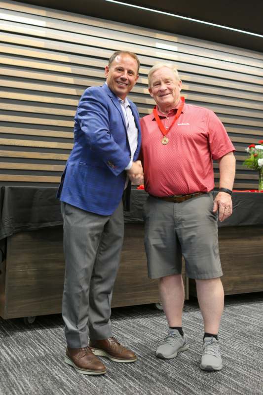 two men shaking hands in front of a table