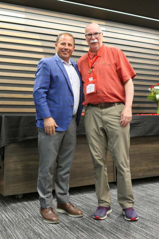 two men standing together smiling