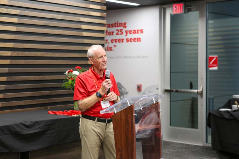 a man standing at a podium speaking into a microphone
