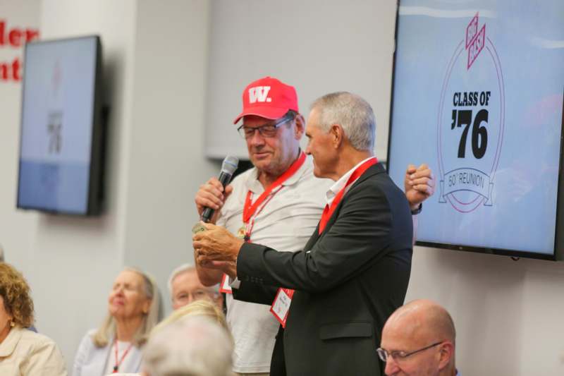 a man holding a microphone and another man holding a microphone