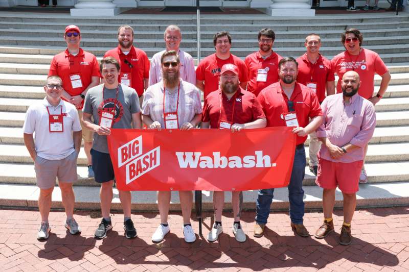 a group of people wearing matching outfits holding a banner