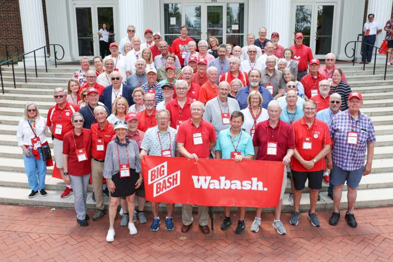 a group of people wearing red shirts and holding a banner