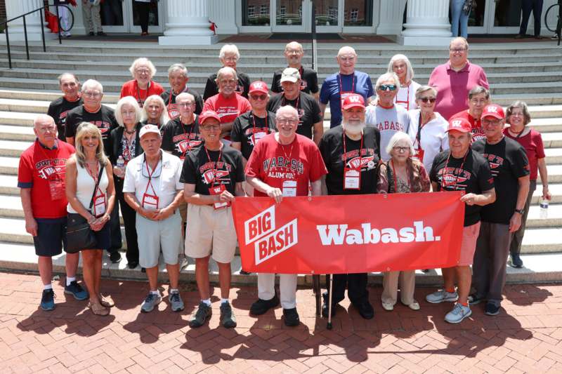 a group of people standing together holding a banner