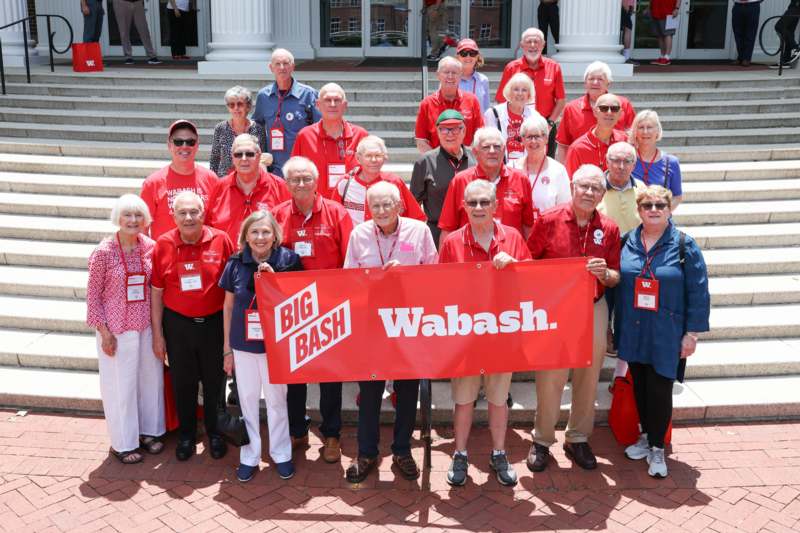 a group of people wearing matching outfits holding a banner