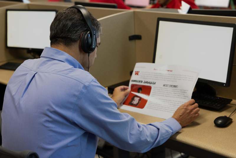 a man wearing headphones looking at a piece of paper
