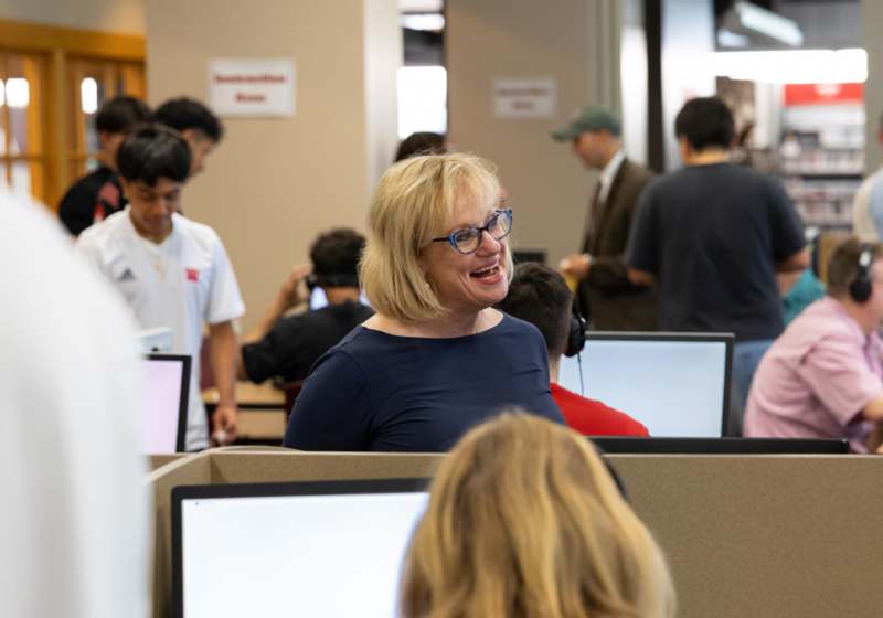 a woman in a blue shirt smiling at a group of people