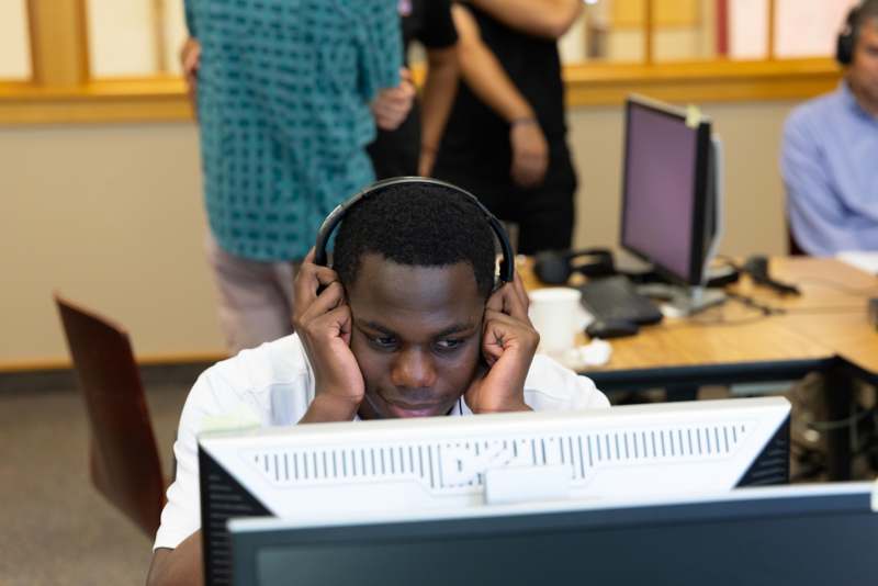a man wearing headphones sitting at a computer