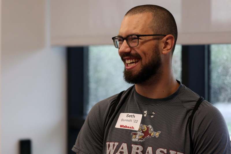 a man wearing glasses and a shirt with a name tag