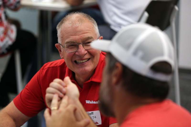 a man in a red shirt holding another man's hand