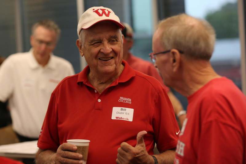 a man in red shirt giving a thumbs up