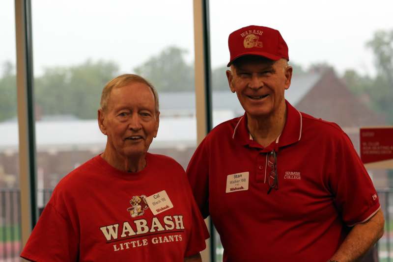 two men wearing matching red shirts