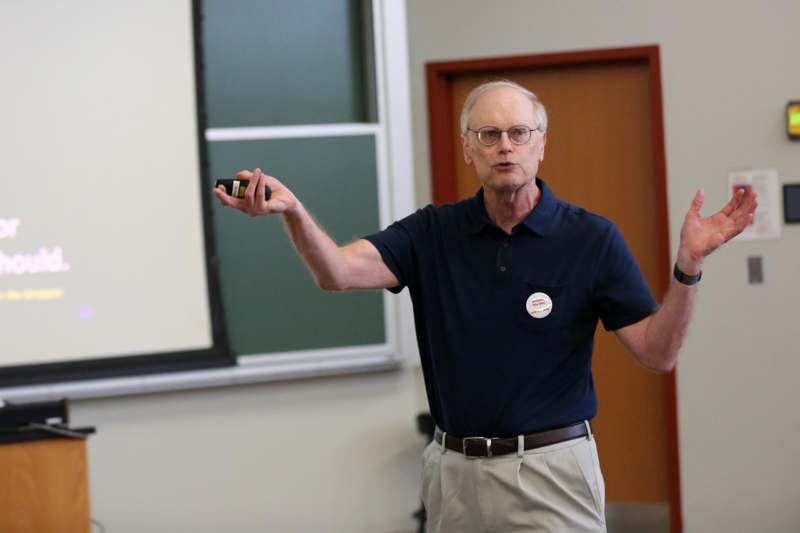 a man in a blue shirt holding a black object in his hand