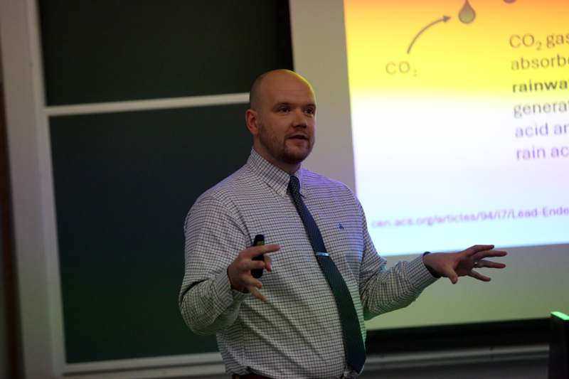 a man in a tie giving a presentation
