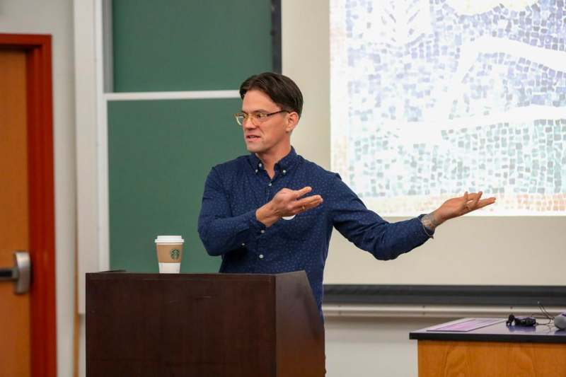 a man standing at a podium with his hands out