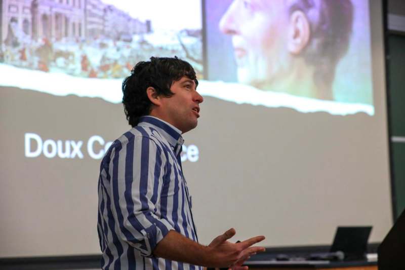 a man standing in front of a projection screen