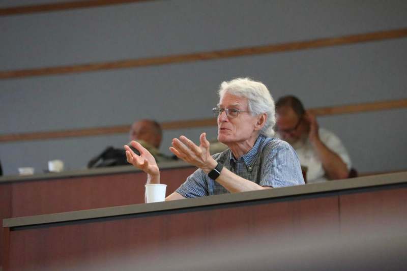 a man sitting in a room with his hands raised