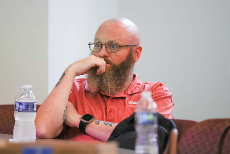 a man with a beard and glasses sitting at a table