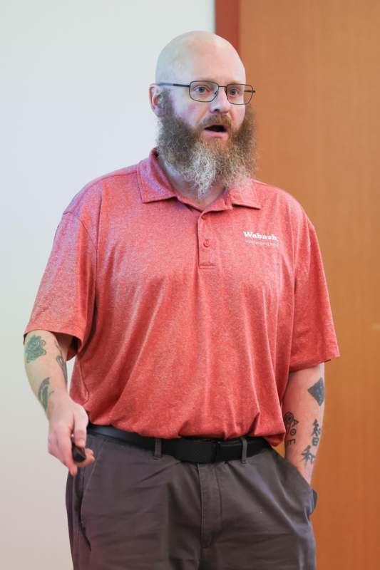 a man with a beard wearing glasses and a red shirt