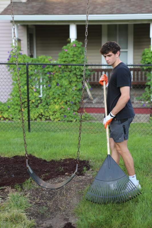 a man holding a rake and a swing
