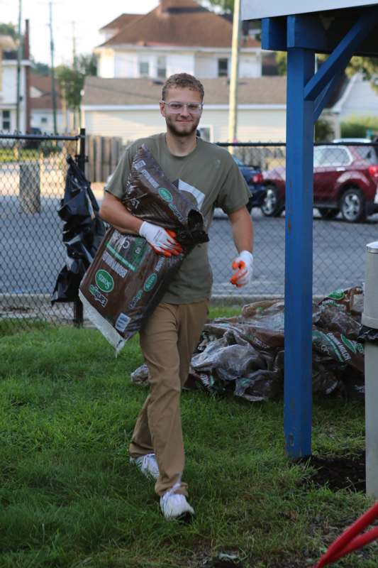 a man carrying a bag of dirt