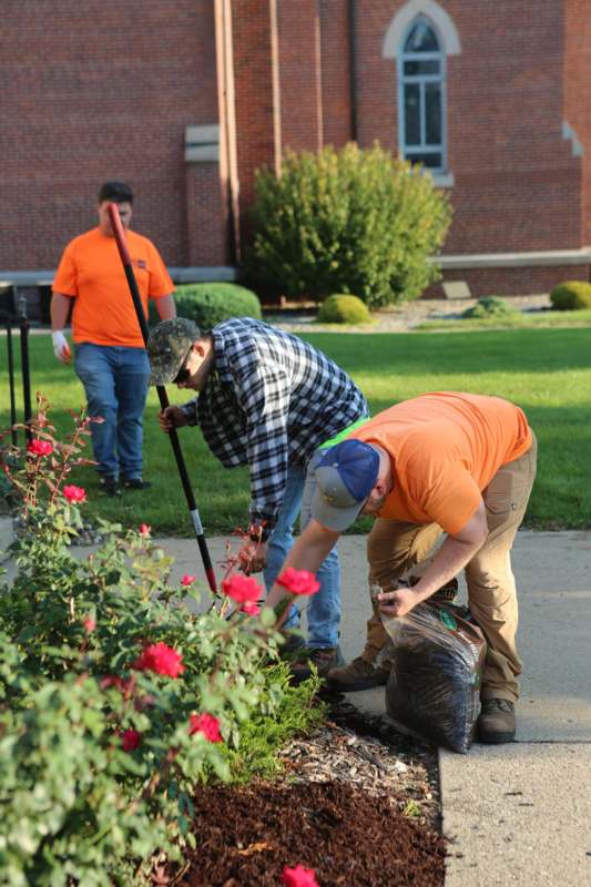 a group of men cleaning a garden
