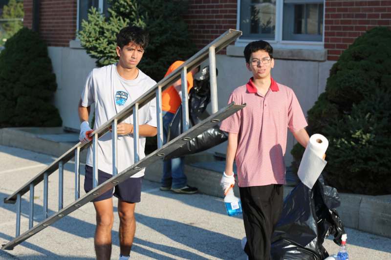 a group of men carrying a ladder and a bag of toilet paper