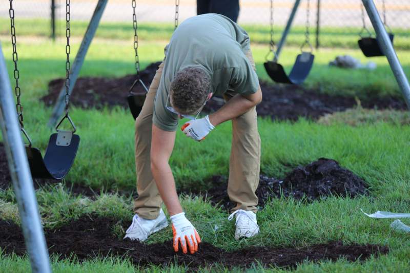 a man in gloves digging in the dirt
