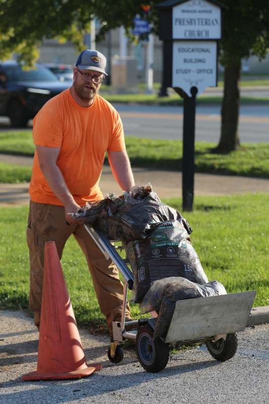 a man pushing a cart with garbage bags