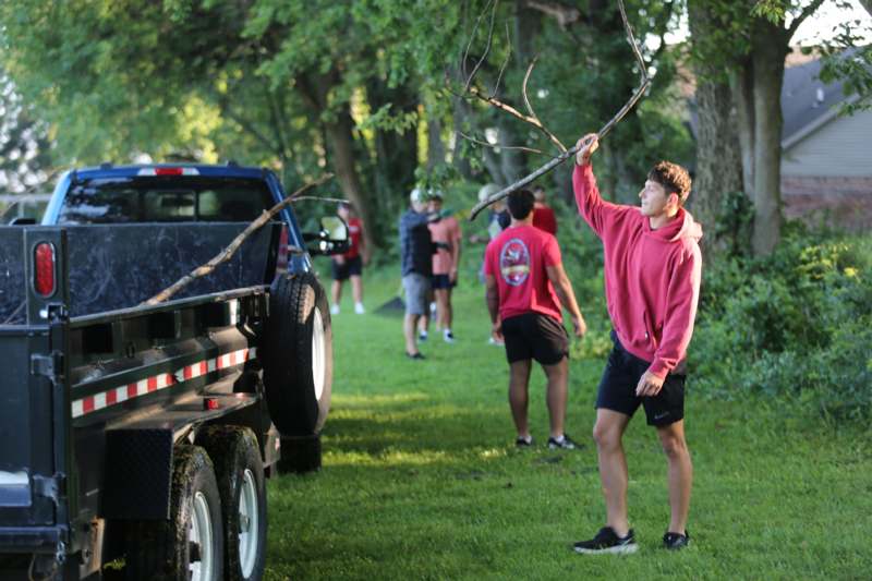 a man holding a stick up to a truck
