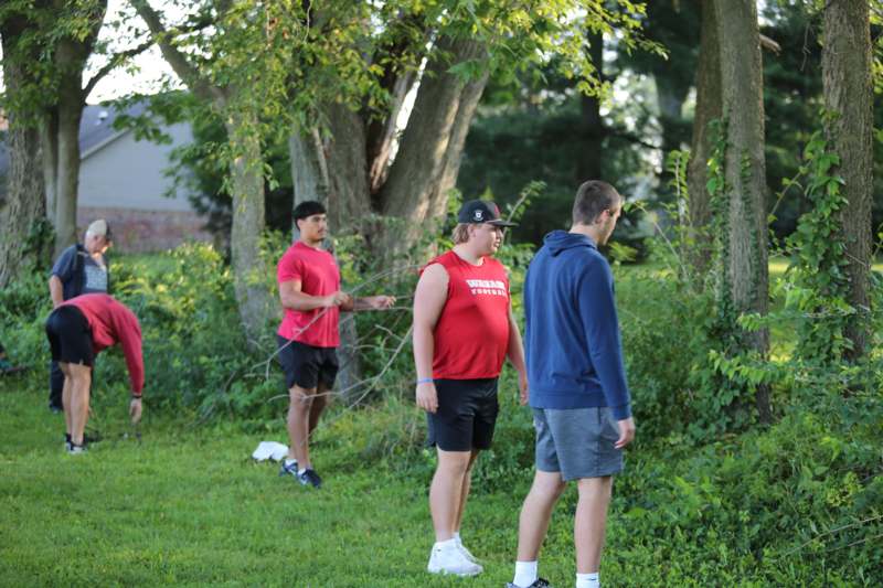 a group of men standing in a grassy area
