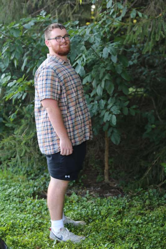 a man standing in front of a tree