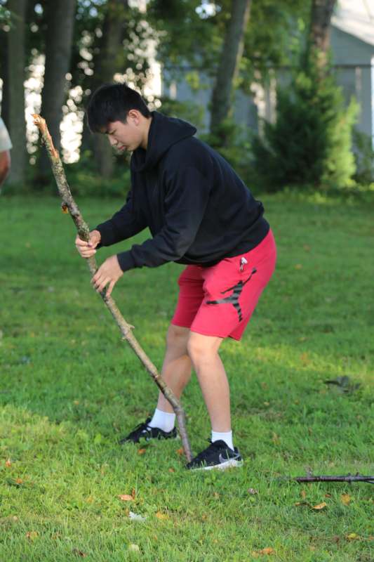 a man holding a stick in a grassy area