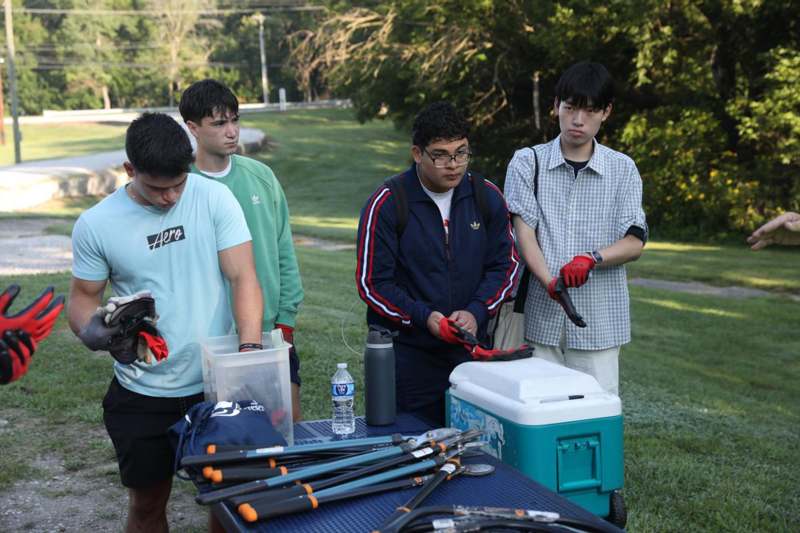 a group of men standing next to a table with tools