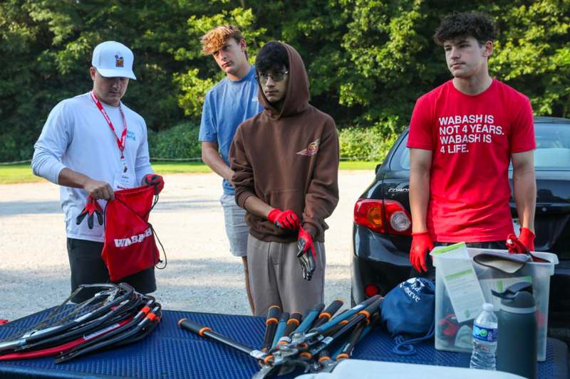 a group of men standing next to a table with tools