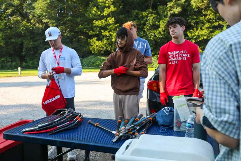 a group of people standing next to a table with tools