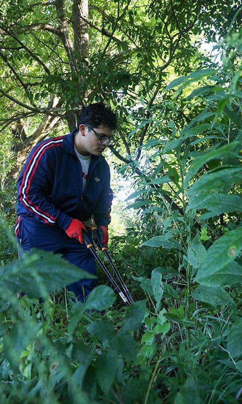 a man in a blue suit with red gloves and black gloves holding a pair of poles in a forest