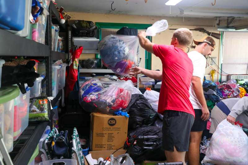 a man holding a plastic bag in a room full of bags