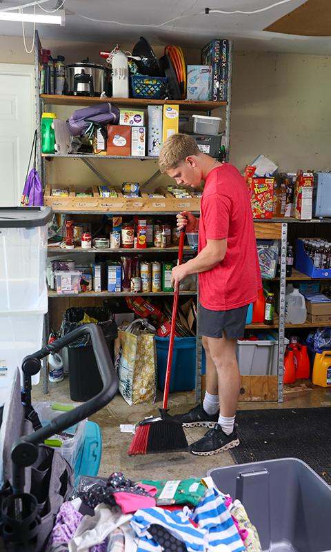 a man sweeping the floor in a garage
