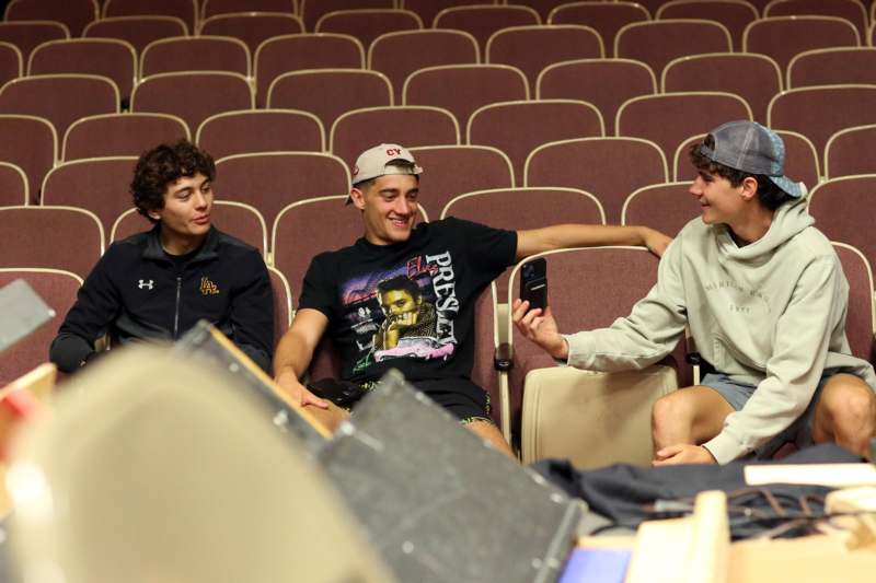 a group of men sitting in chairs in a theater