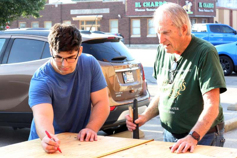 a man and a man working on a wood plank