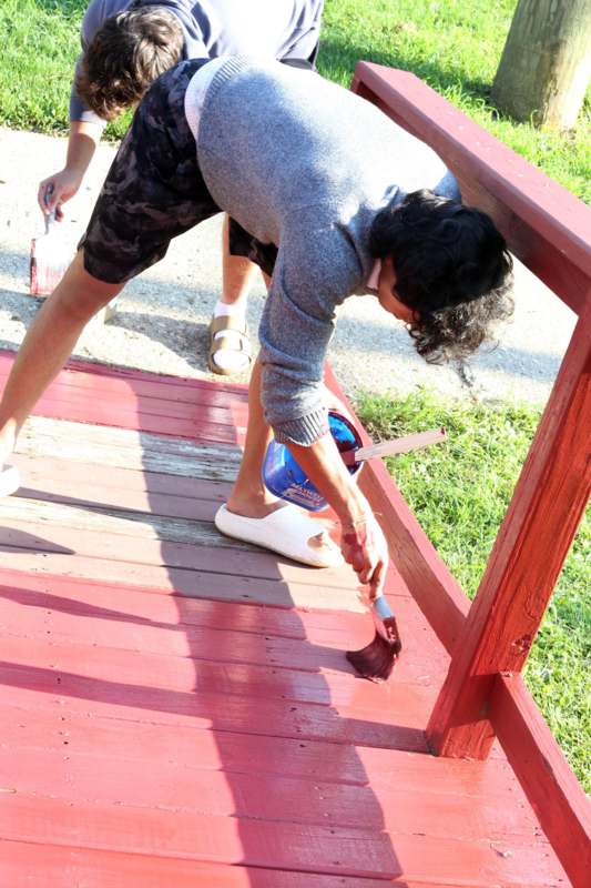 a man painting a red deck