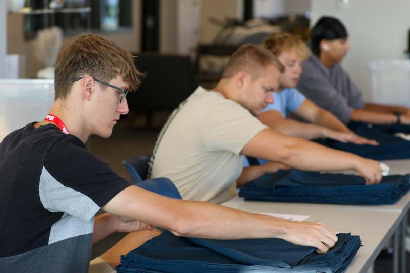 a group of people folding clothes
