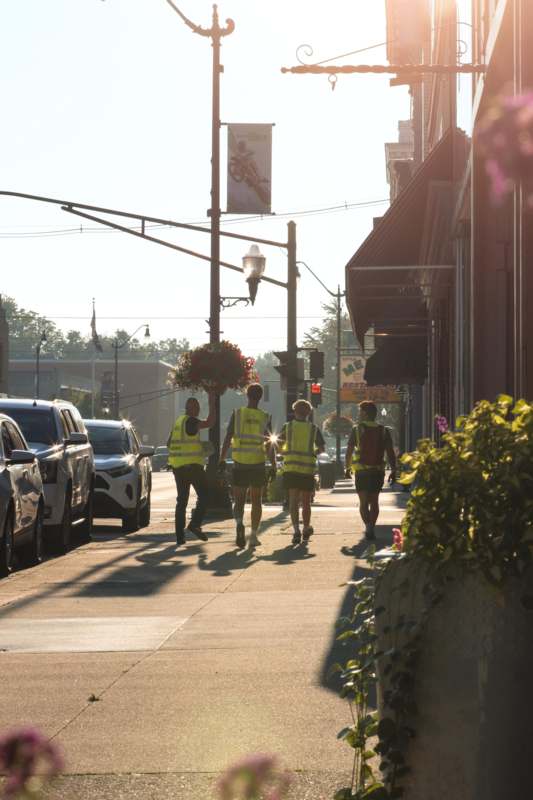 a group of people walking on a sidewalk