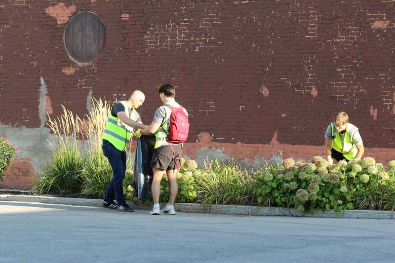 a group of people standing next to a brick wall