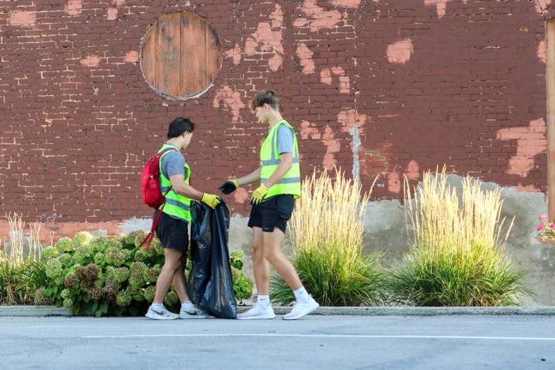two men wearing reflective vests and a black bag